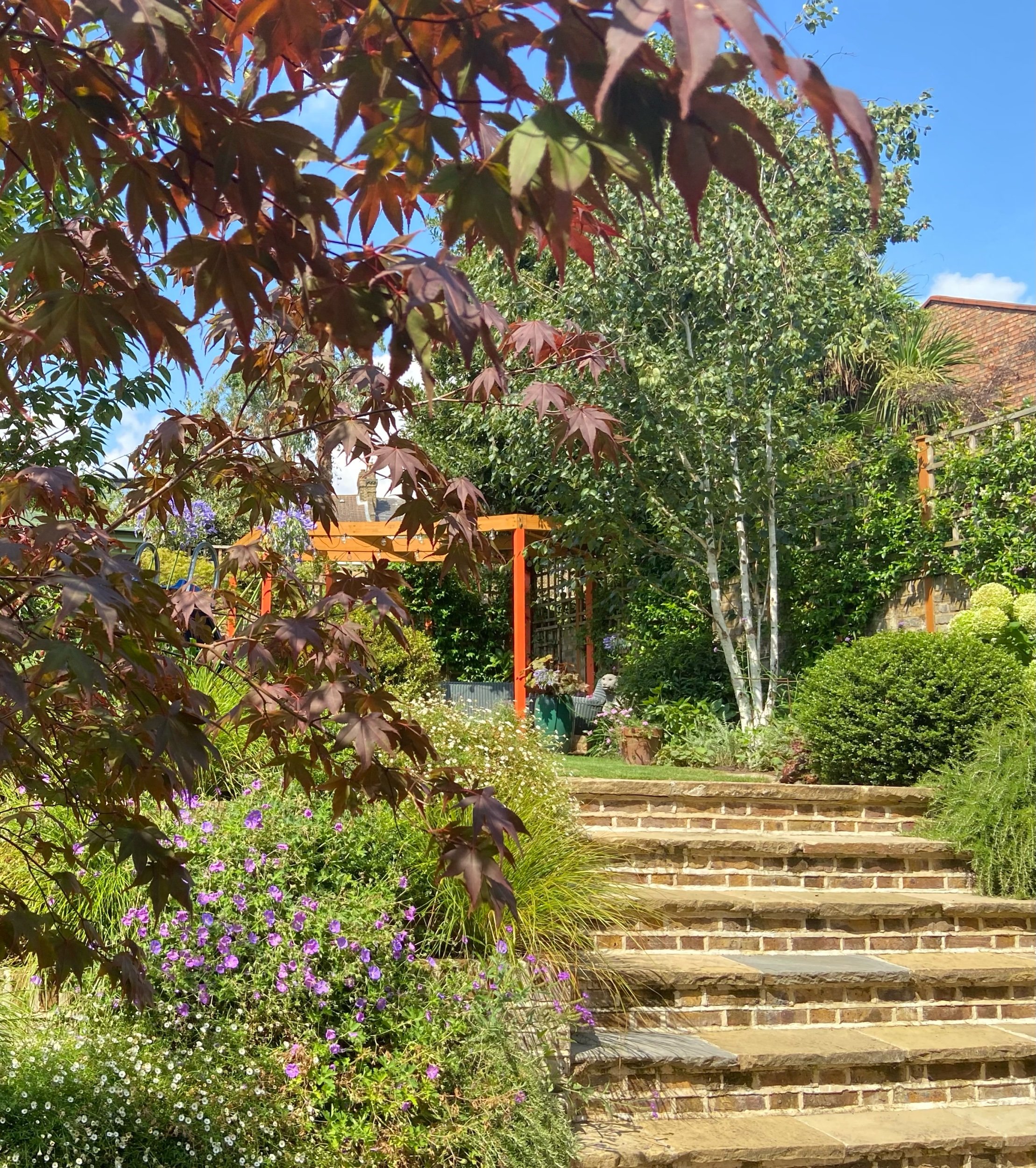 Steps leading up to a family friendly garden designed by Living Gardens in North London