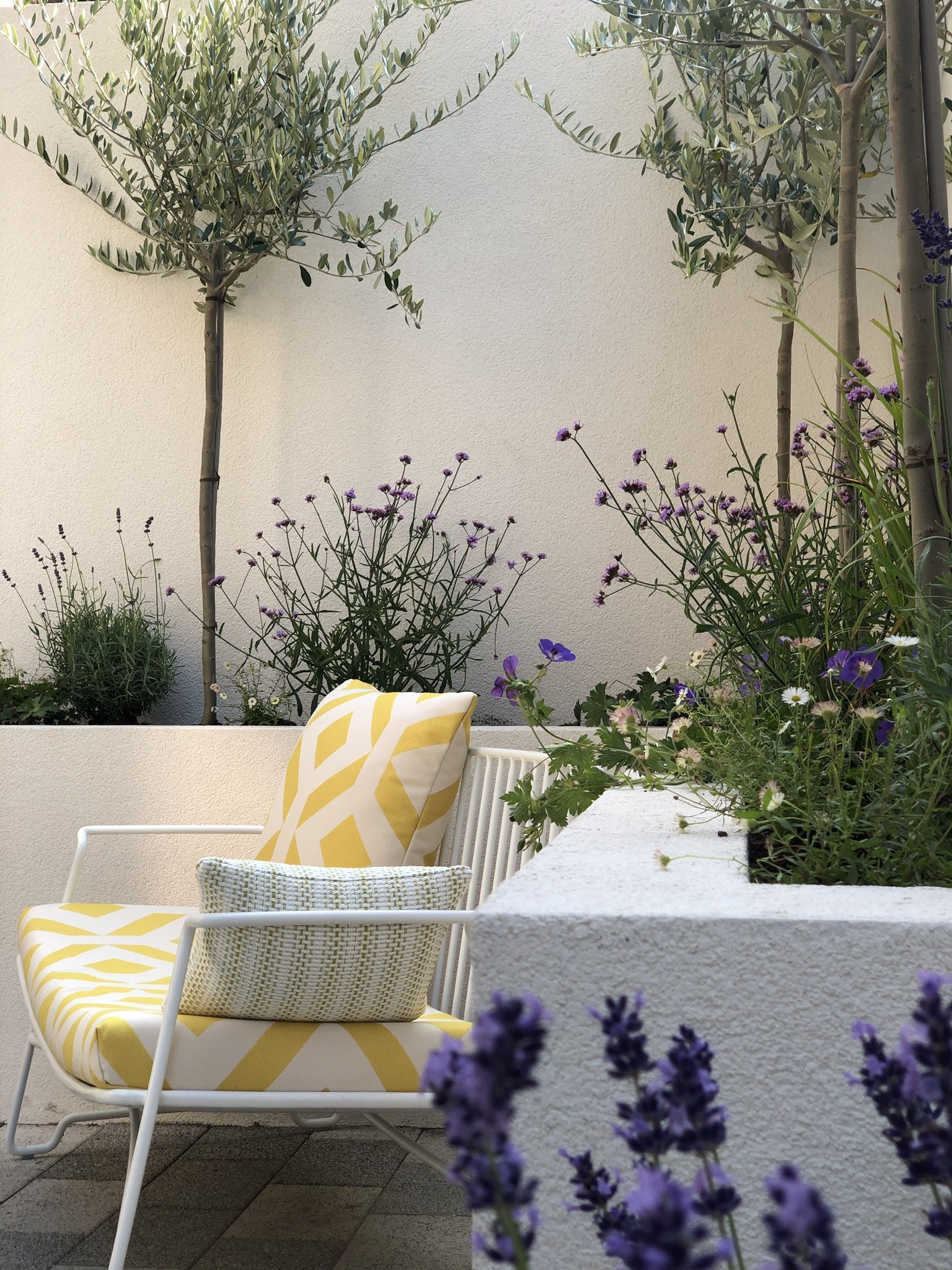 Bespoke landscape gardeners create raised borders around a seating area