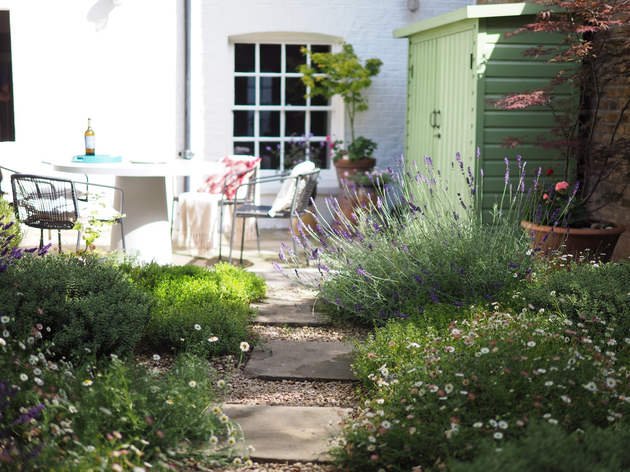 Small London garden design with white walls and a path leading to the patio