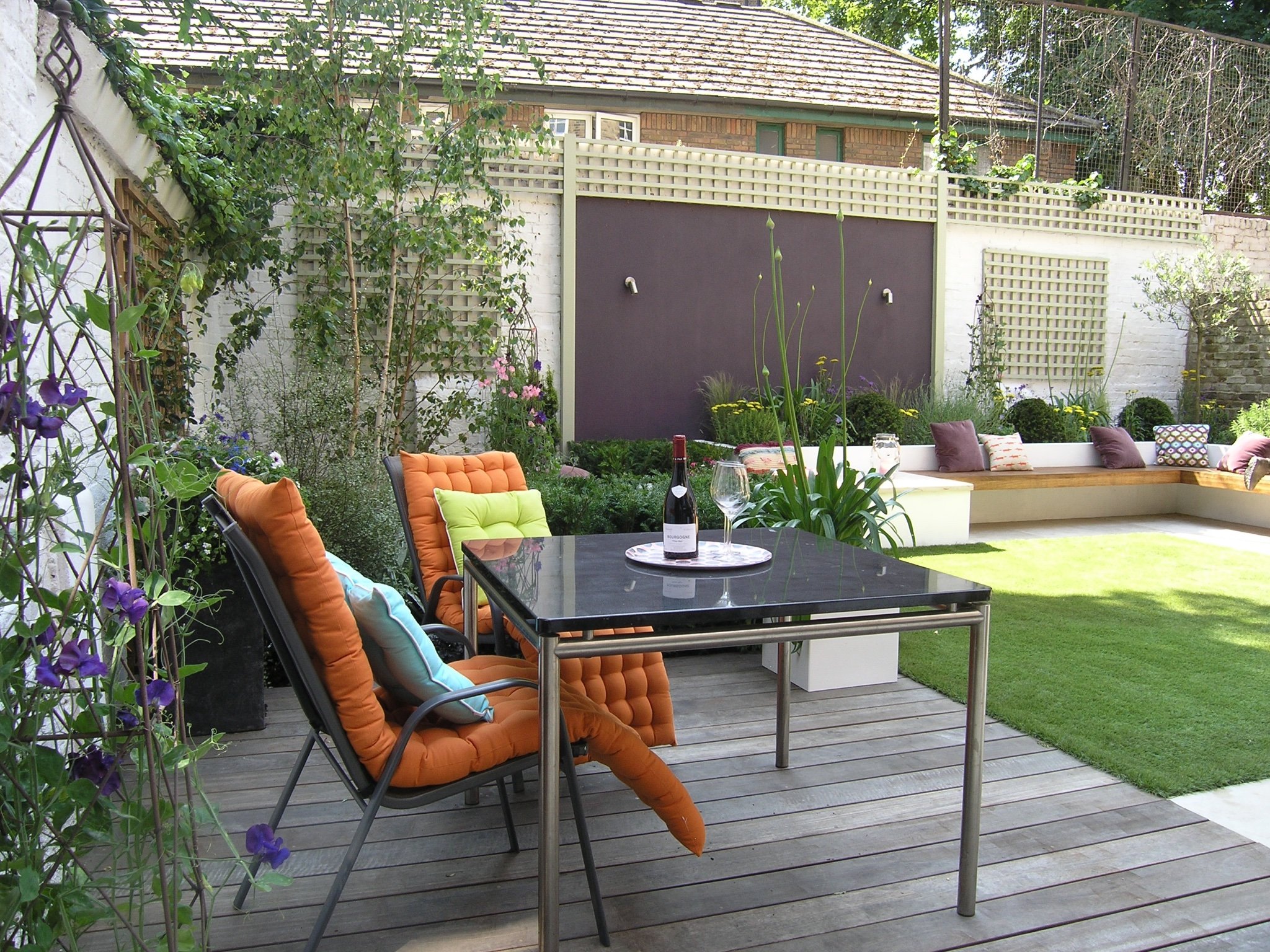 Decking area with tables and chairs in a modern garden design in North London