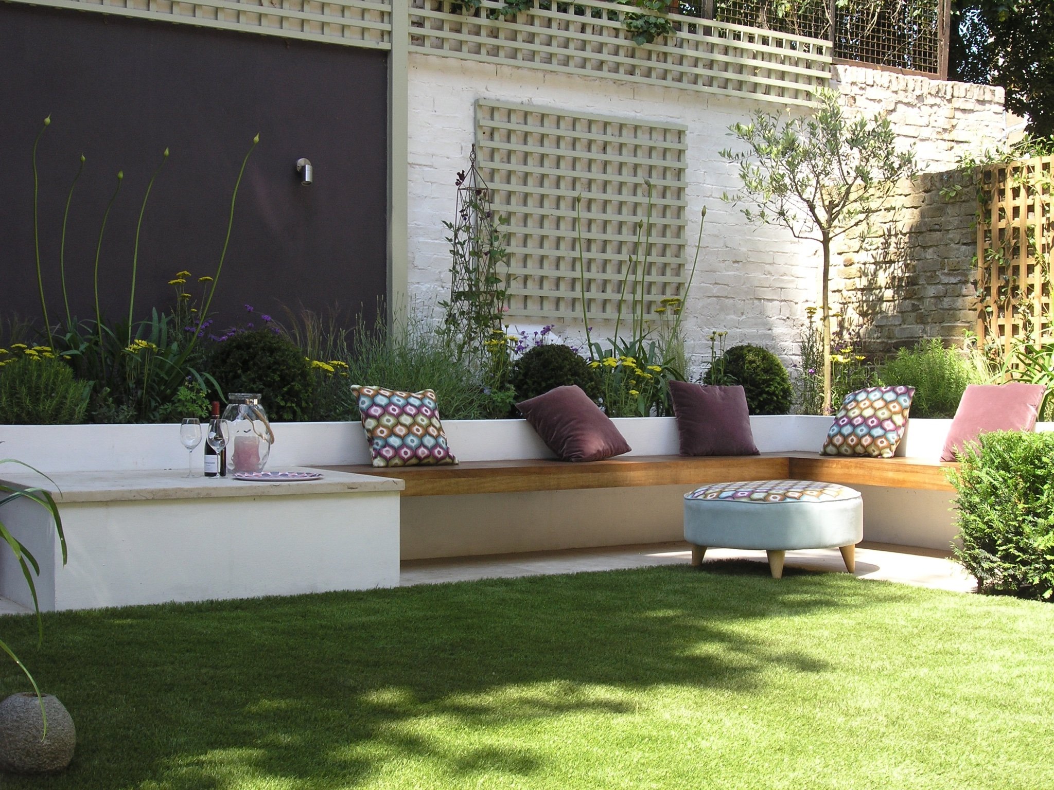 Benches with cushions in a modern garden designed by landscape gardeners in North London