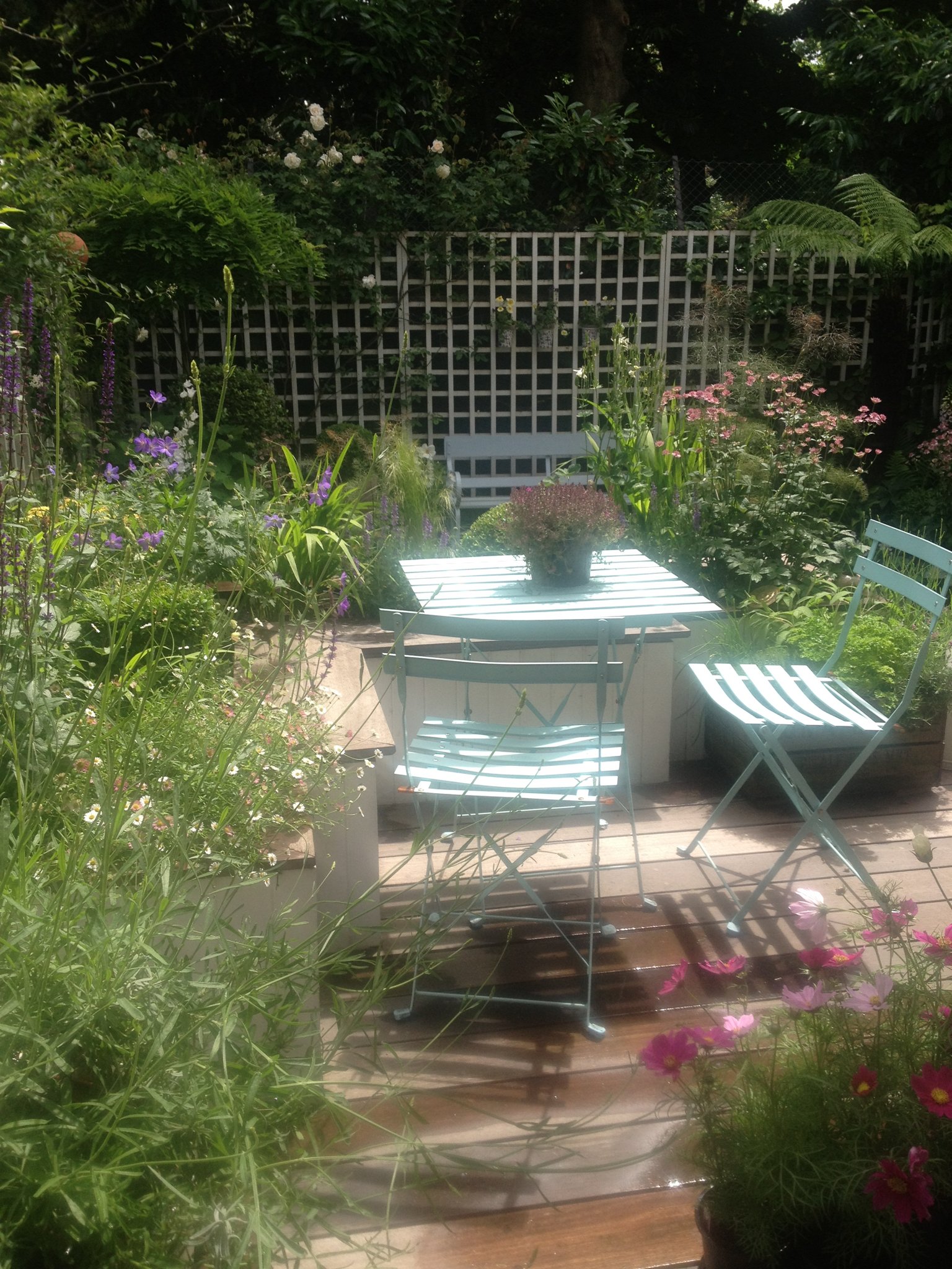 Dining area amongst the flowers in a garden designed by Living Gardens in North London