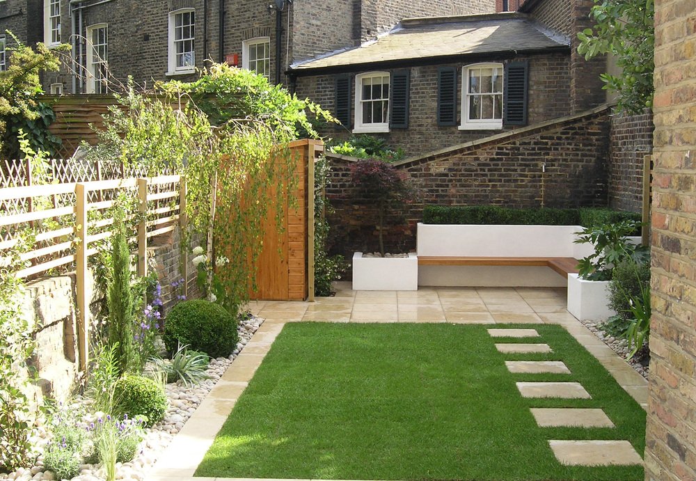  Modern garden design in a period property in Canonbury with a rectangular lawn surrounded by limestone paving and low maintenance borders. 