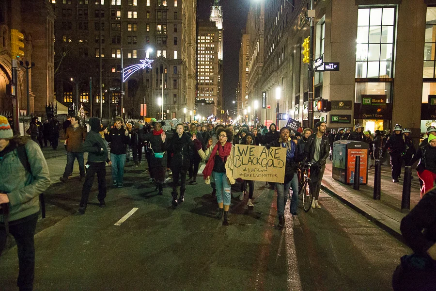 Protestors march south on Broadway past Wall St. 