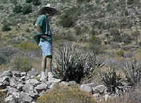 Ted stands over an old foundation to a long disintegrated building