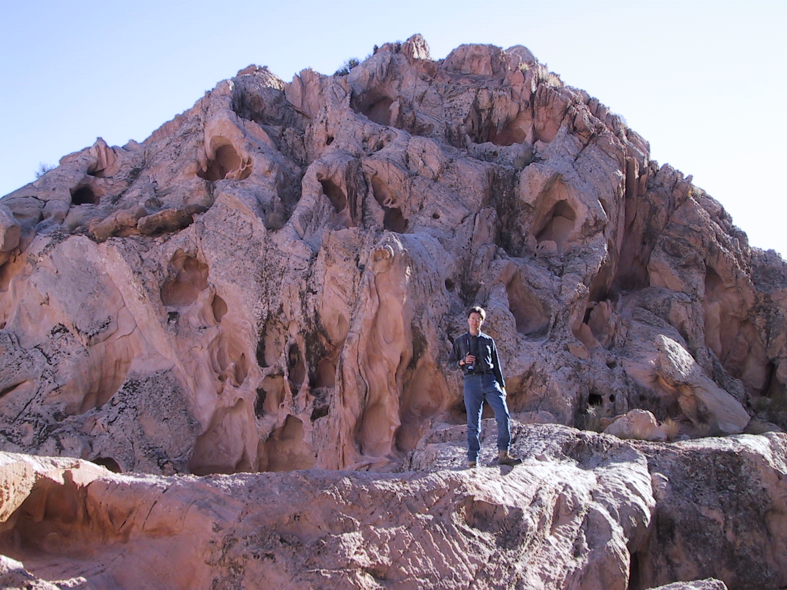 Joe posing in front of an eroded rock hill 
