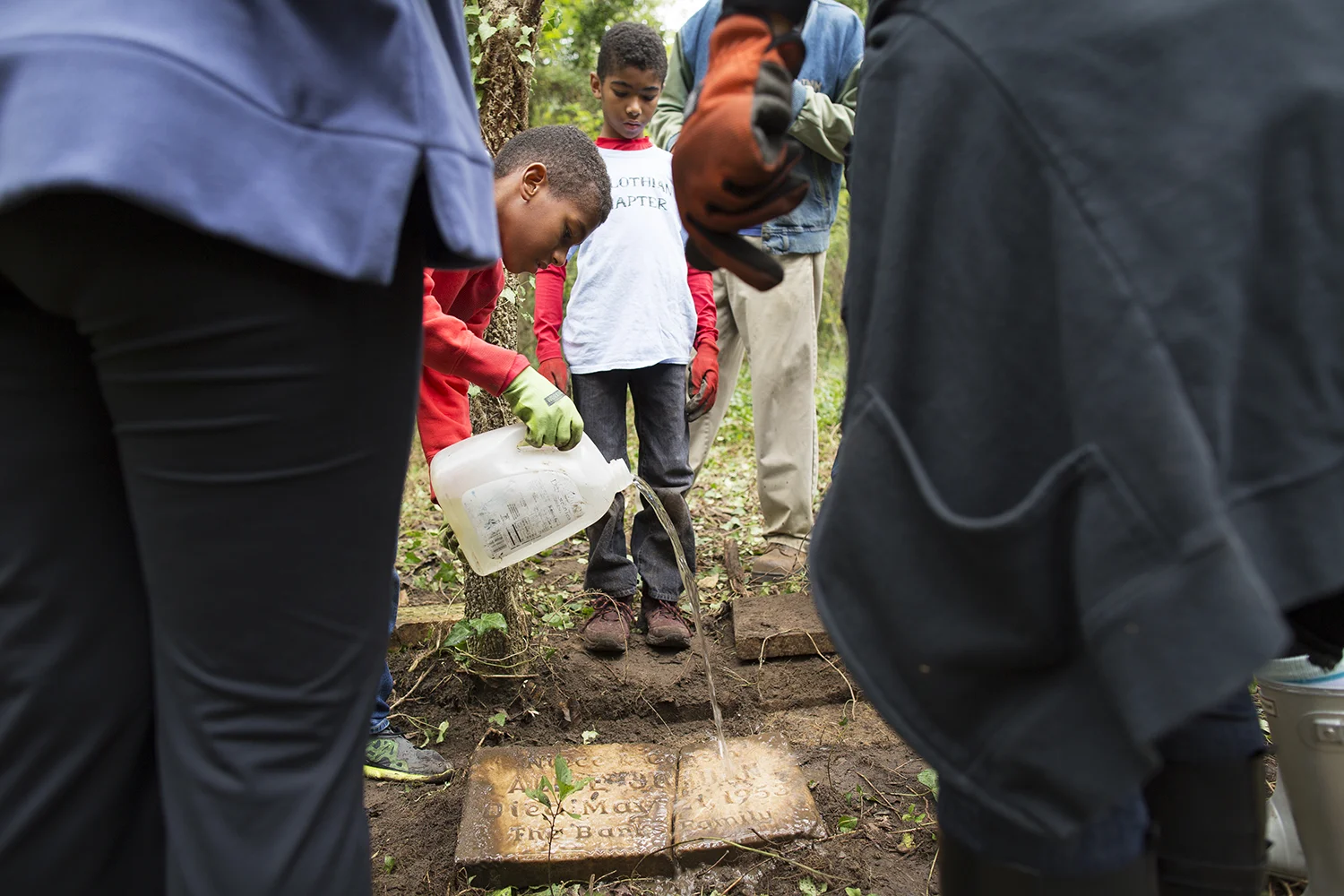 Volunteers from Jack and Jill's Midlothian chapter wash one of the headstones they unearthed. East End Cemetery, Henrico County, Virginia, October 2015. Photo: BP