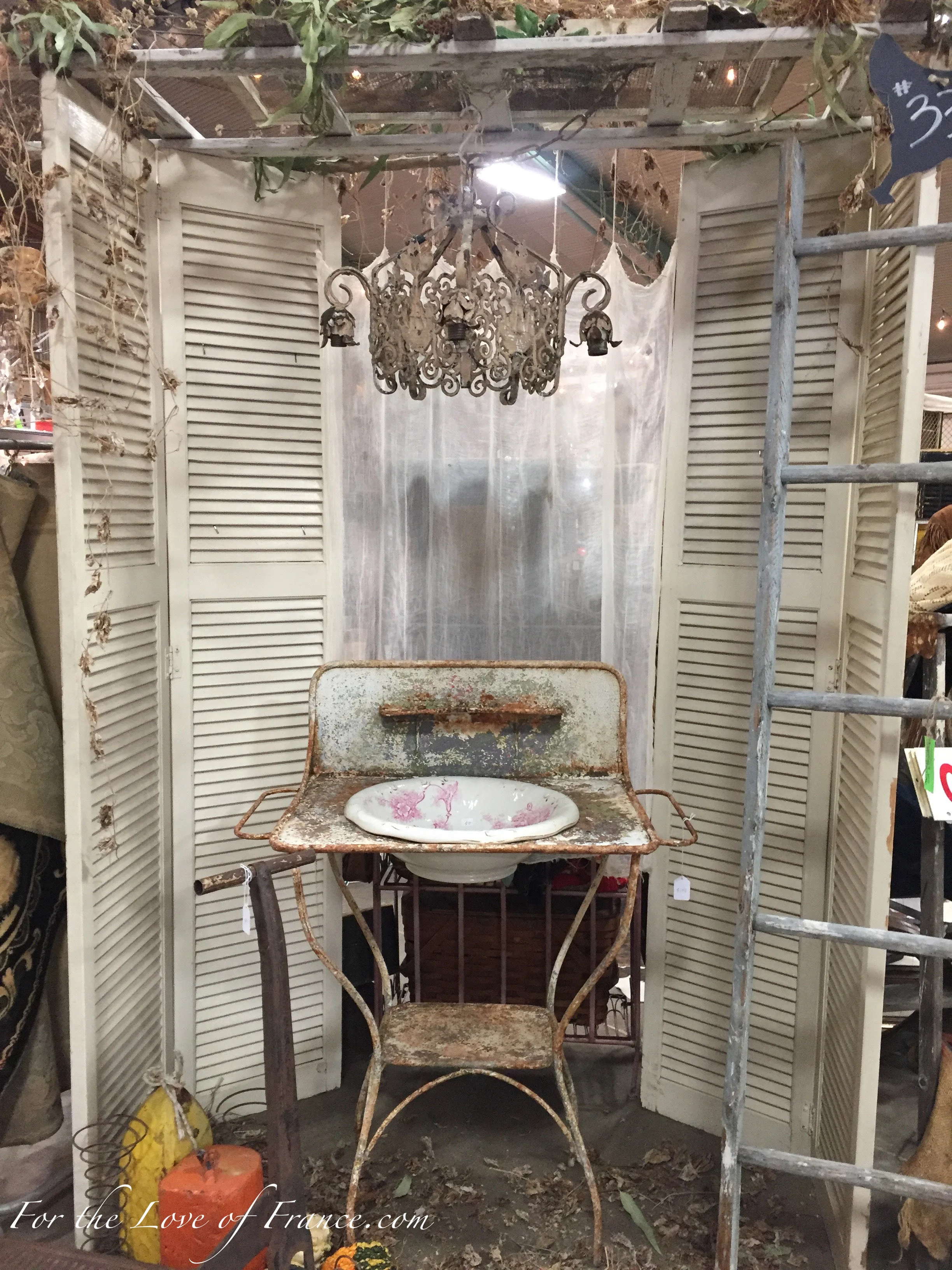 Vintage display with antique French shutters, chandelier, wash basing and stand