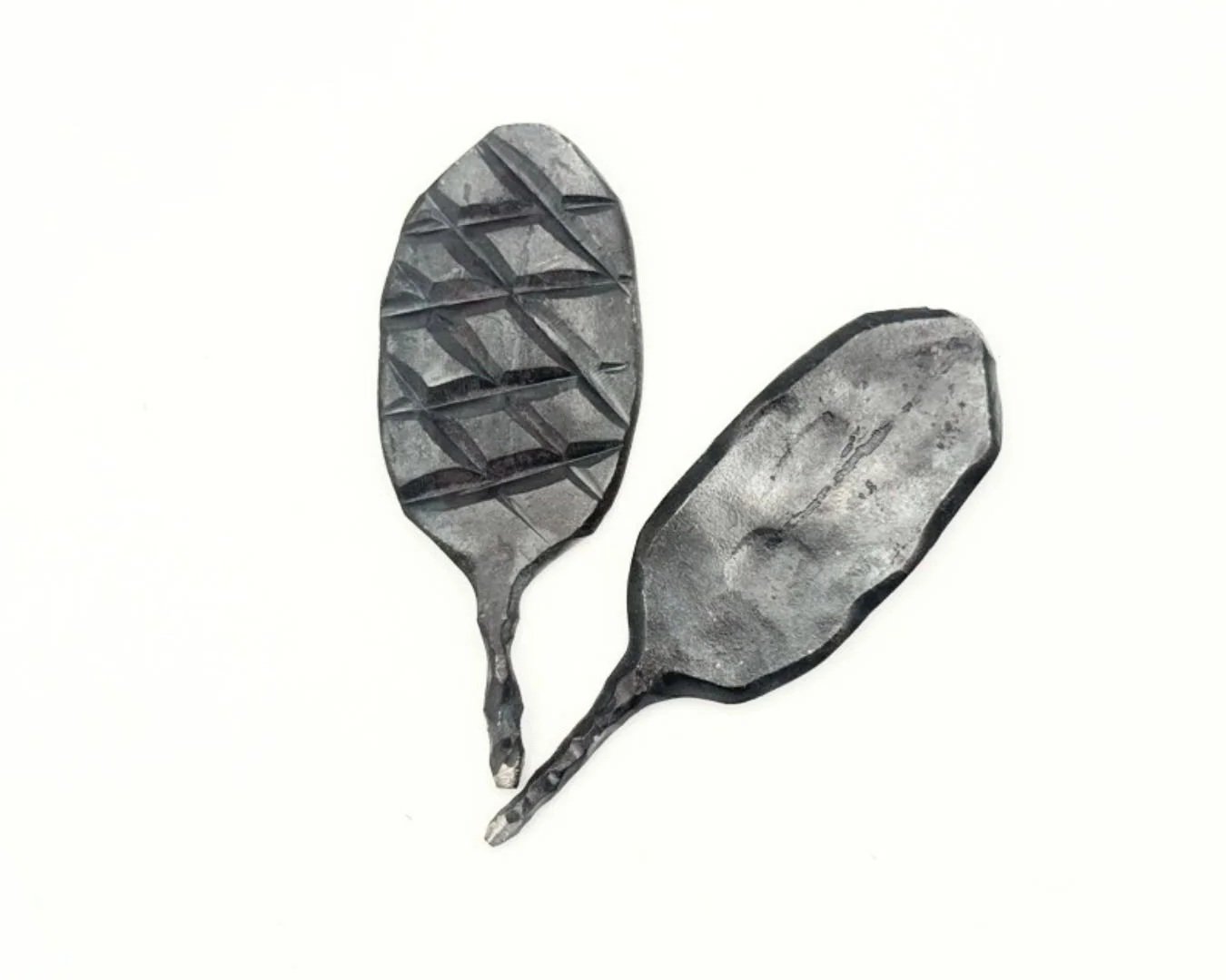 Two steel divot tools for golf on a white background.