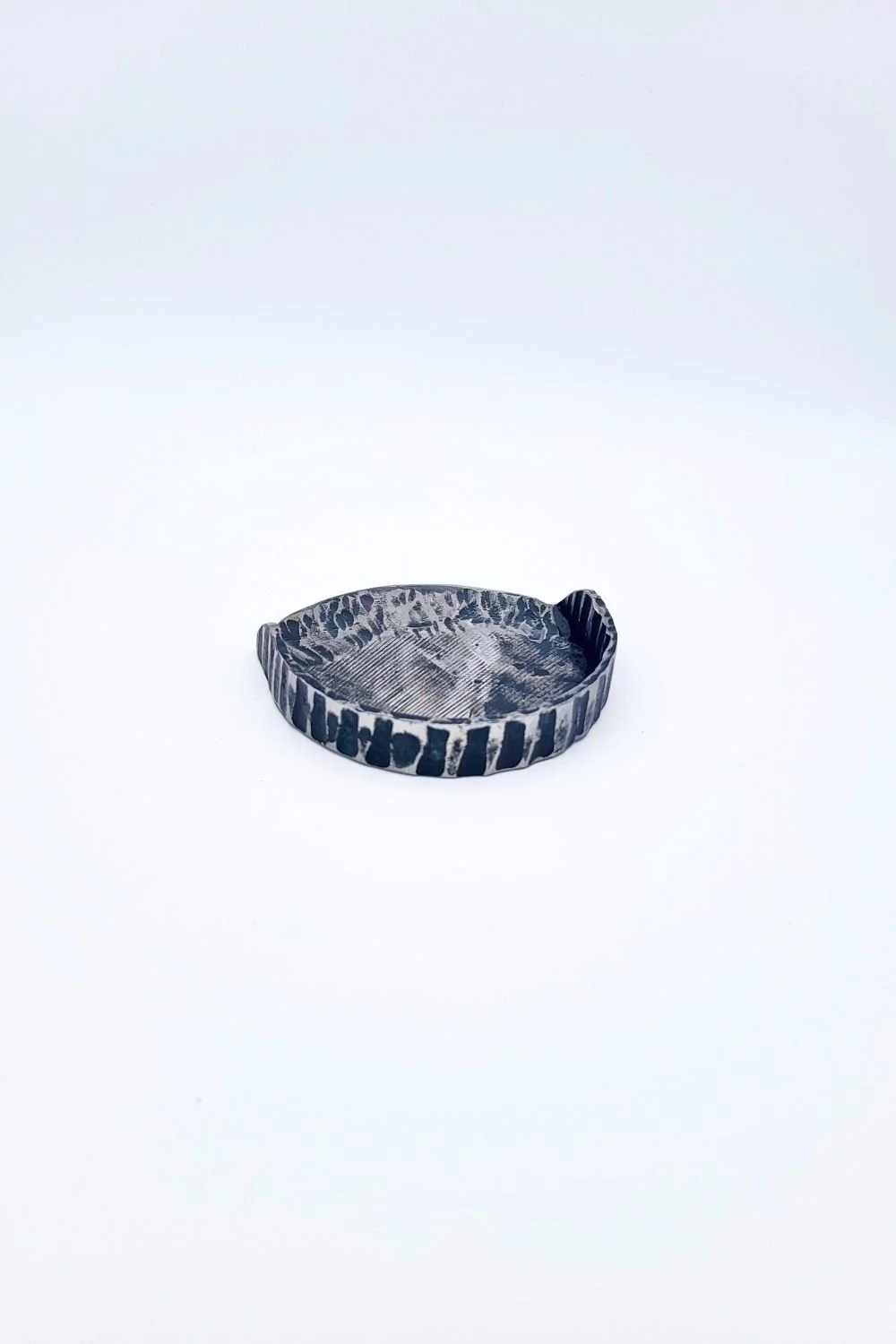Hand-forged steel putting cup against a white background.
