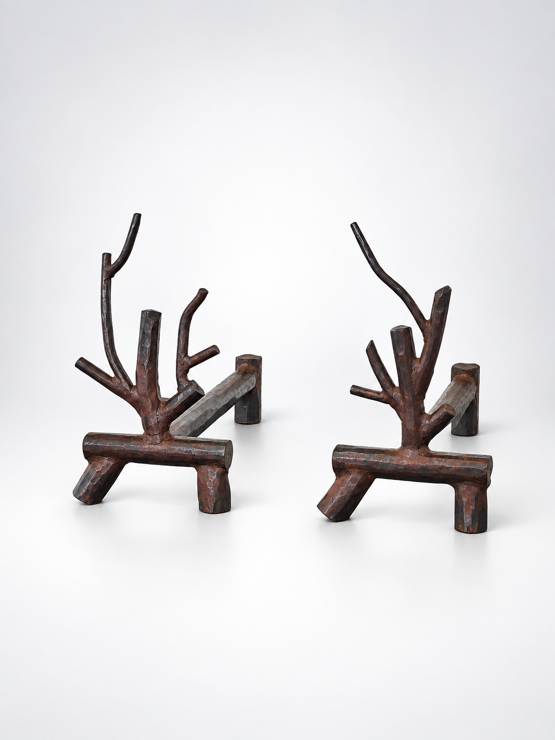 Metal andirons with rhododendron branch details against a white gradient background.