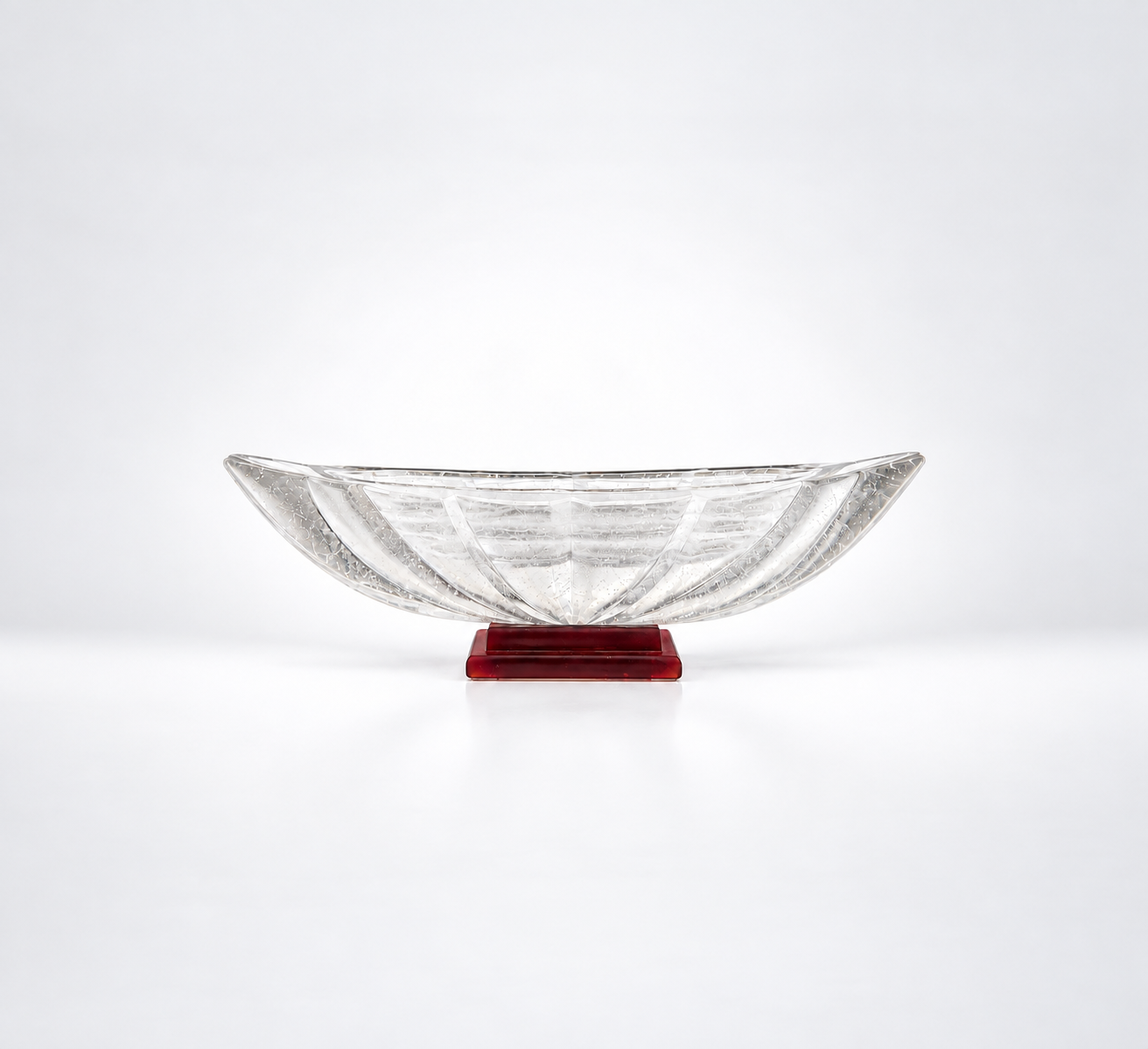 Clear cast glass sculpture with a red glass base against a gradient white background by artist Rick Beck.