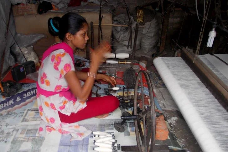 A woman spins bobbins (bottom, center) from a single yarn bundle.