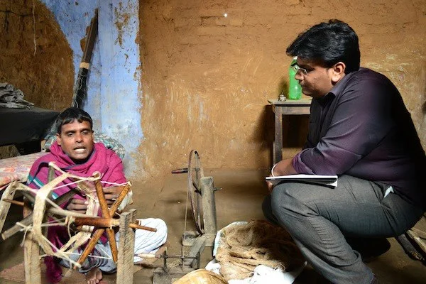 Sanjeev (left) explains the process of spinning bobbins to Upaya's Sriram Gutta. January 2013.