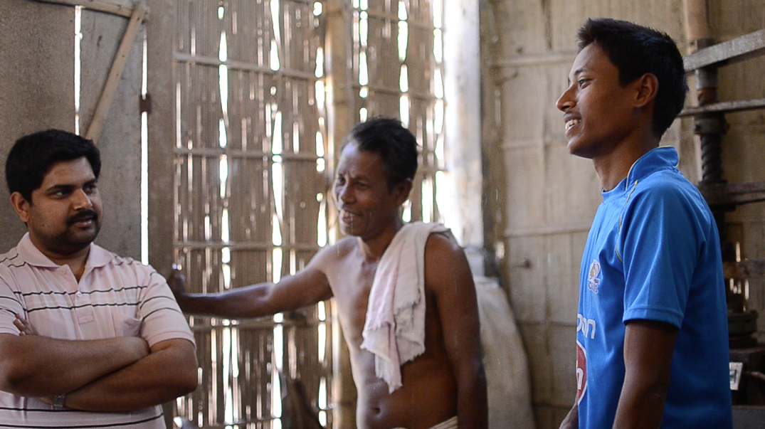 Jituparna (right) discusses his plans for expanding the production unit and employing others in Patla as his father (center) and Tamul Plates CEO Arindam Dasgupta (left) listen.
