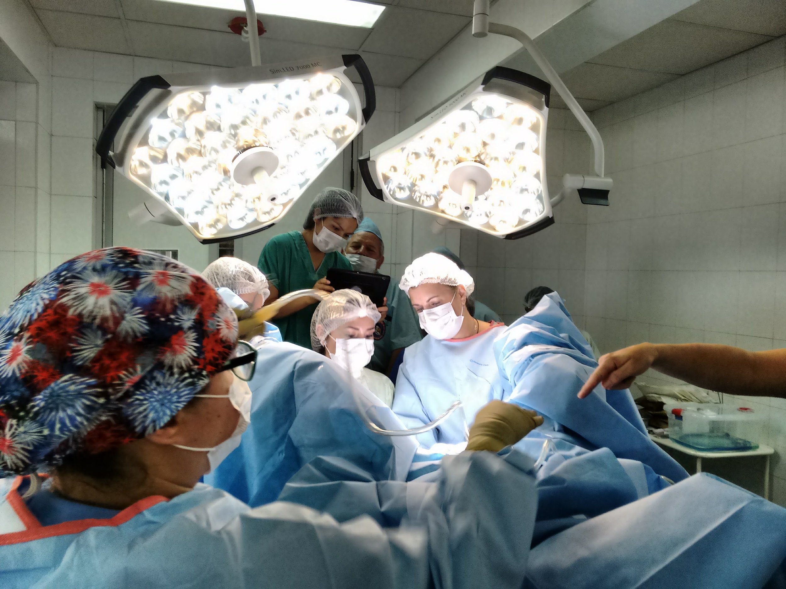  Gaby, in the foreground with red scrub cap, assists during surgery 
