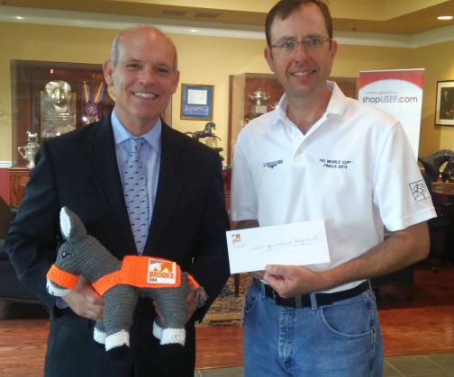 US Equestrian CEO Bill Moroney and CFO David Harris accepting a $25,000 check from Brooke USA for equine victims of Hurricane Harvey.