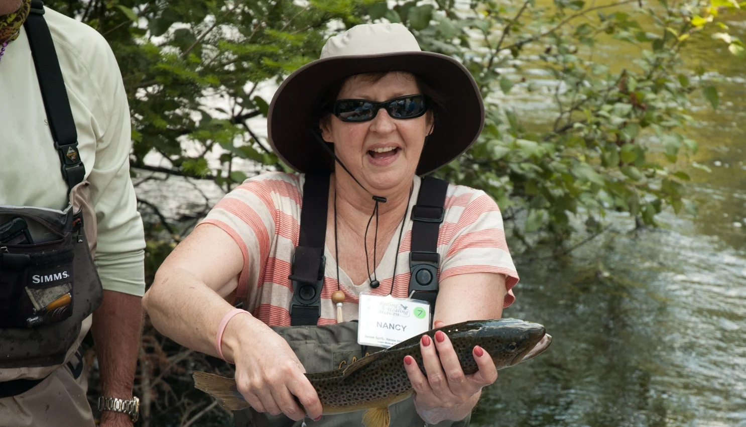 Reeling_and_Healing_Fly_fishing_Wellness_Retreat_Au_Sable_River_Woman_with_Trout_Fish_On