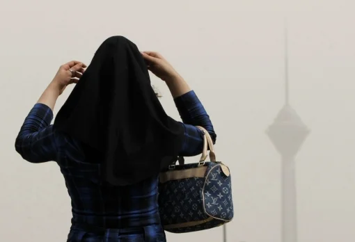 An Iranian woman adjusts her headscarf in central Tehran. Photo: Getty