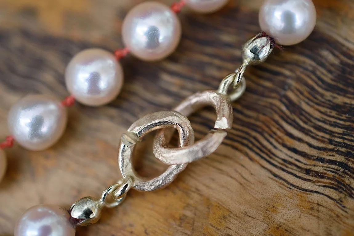 Aparte gouden sluiting geboetseerd van bijenwas maakt een parelcollier weer helemaal NU