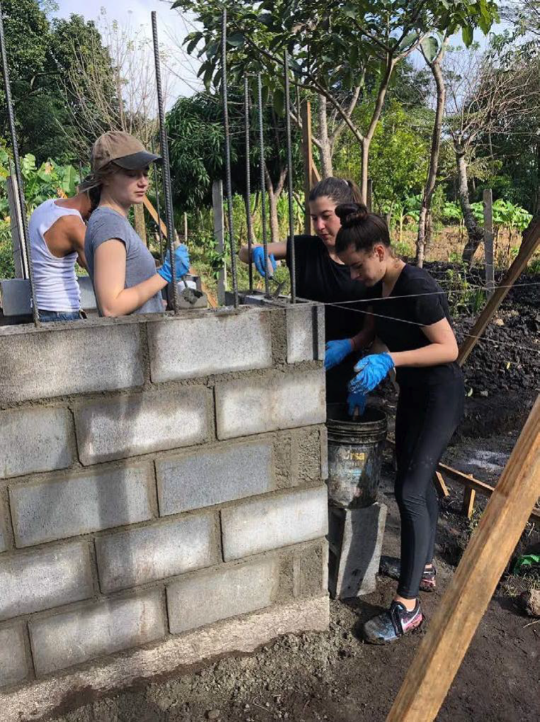  UC Berkley team members help with grouting Well Support Building cement block joints 