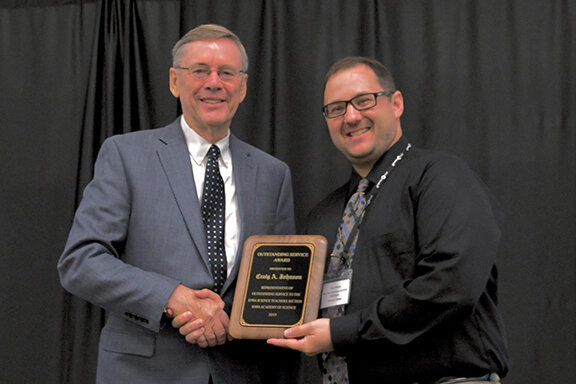 Craig Johnson (L), Executive Director of the Iowa Academy of Science receives an Outstanding Service Award from Jesse Wilcox, Chair of the Iowa Science Teachers Section.