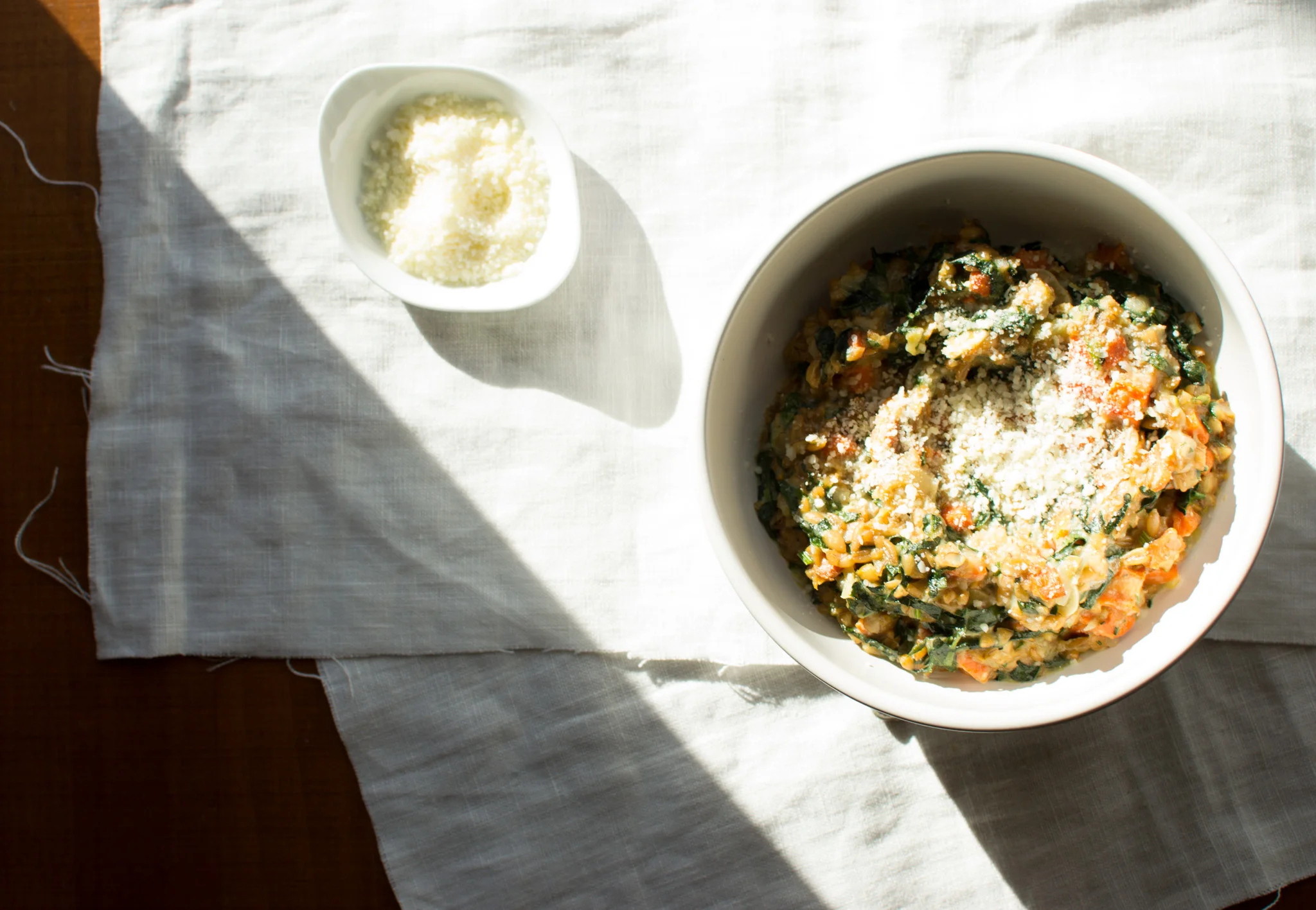 Let the light shine on your farrotto. Drizzle some herbaceous oil over top. Shower on the parmesan cheese.