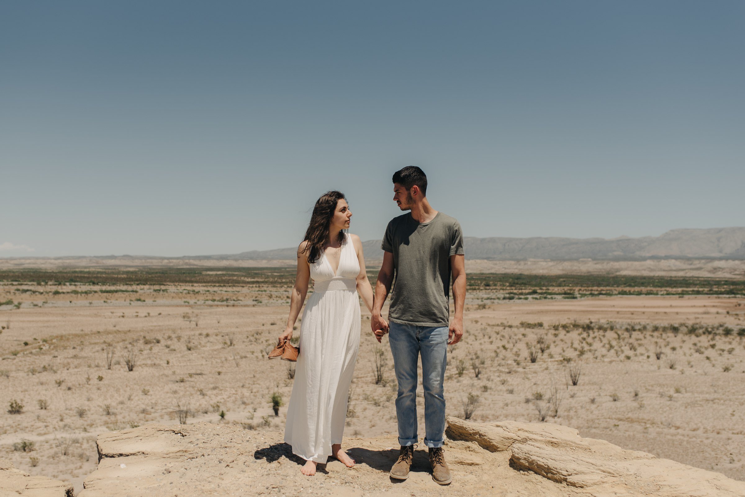  couple standing on top of rock big bend national park adventurous engagement session 