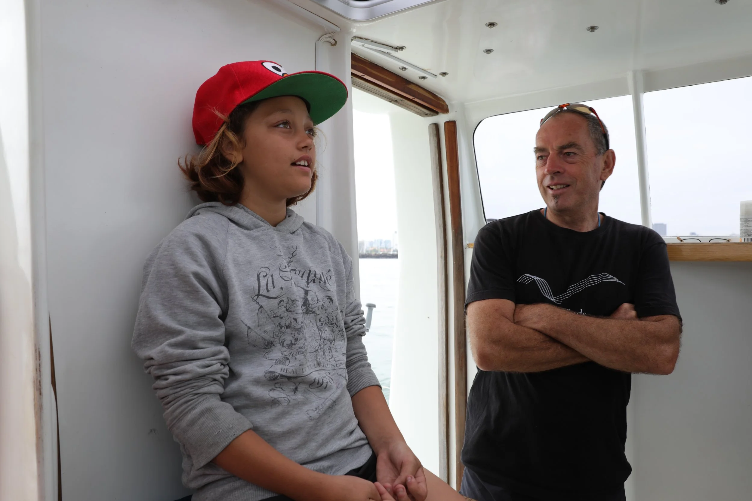 The Captain teaching the youngest on board about Pelican1's auto pilot after he was asked- "Who's driving the boat?"