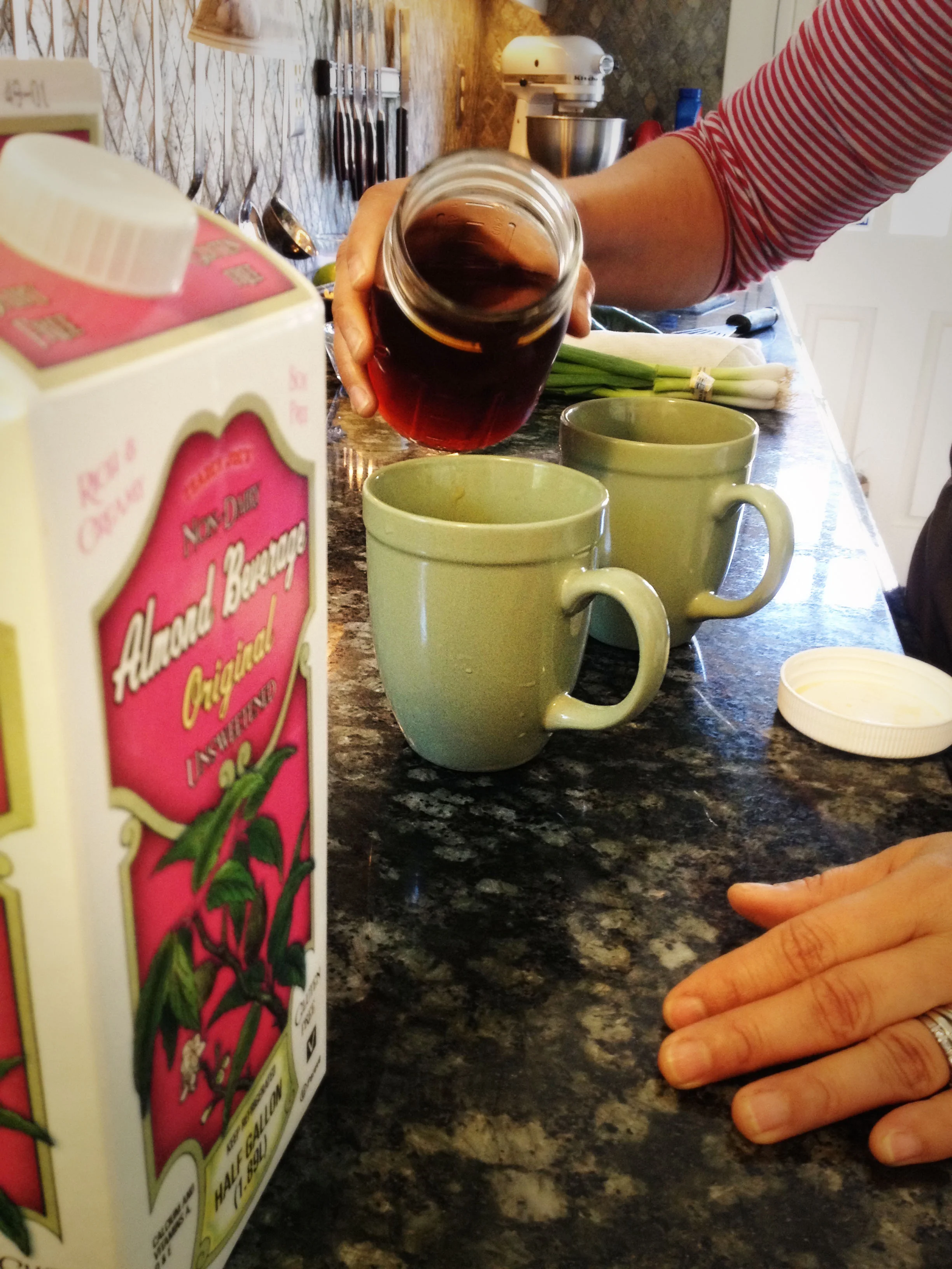Sandra pours concentrated rooibus (an herb) into our chai tea. 
