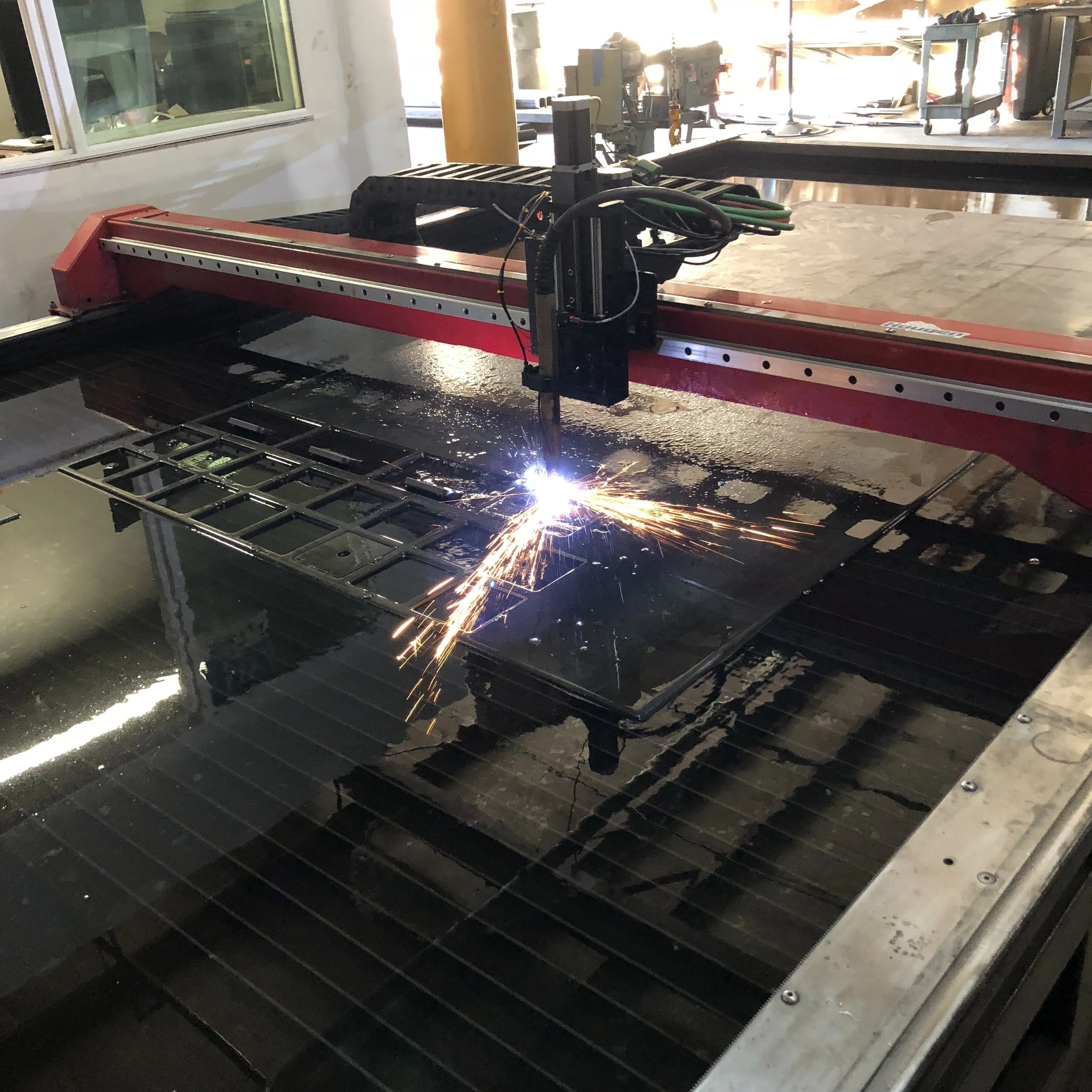 CNC Plasma Cutting 1/2” Plate (submerged in water) for mounting flanges.