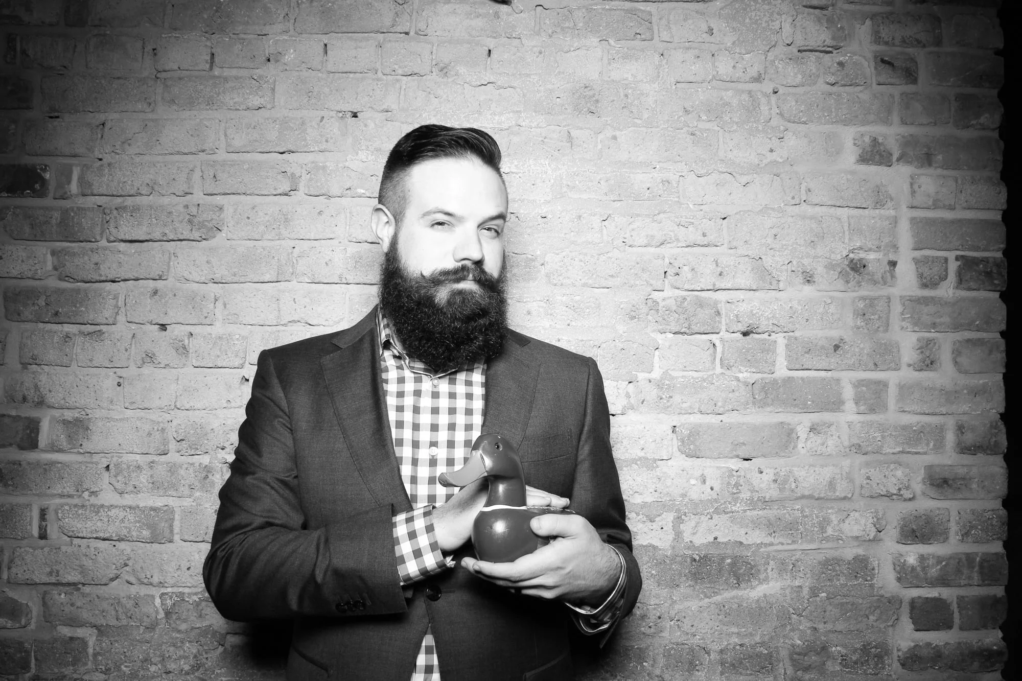 Bearded man holding wooden duck. Digital photograph ca. 2016.