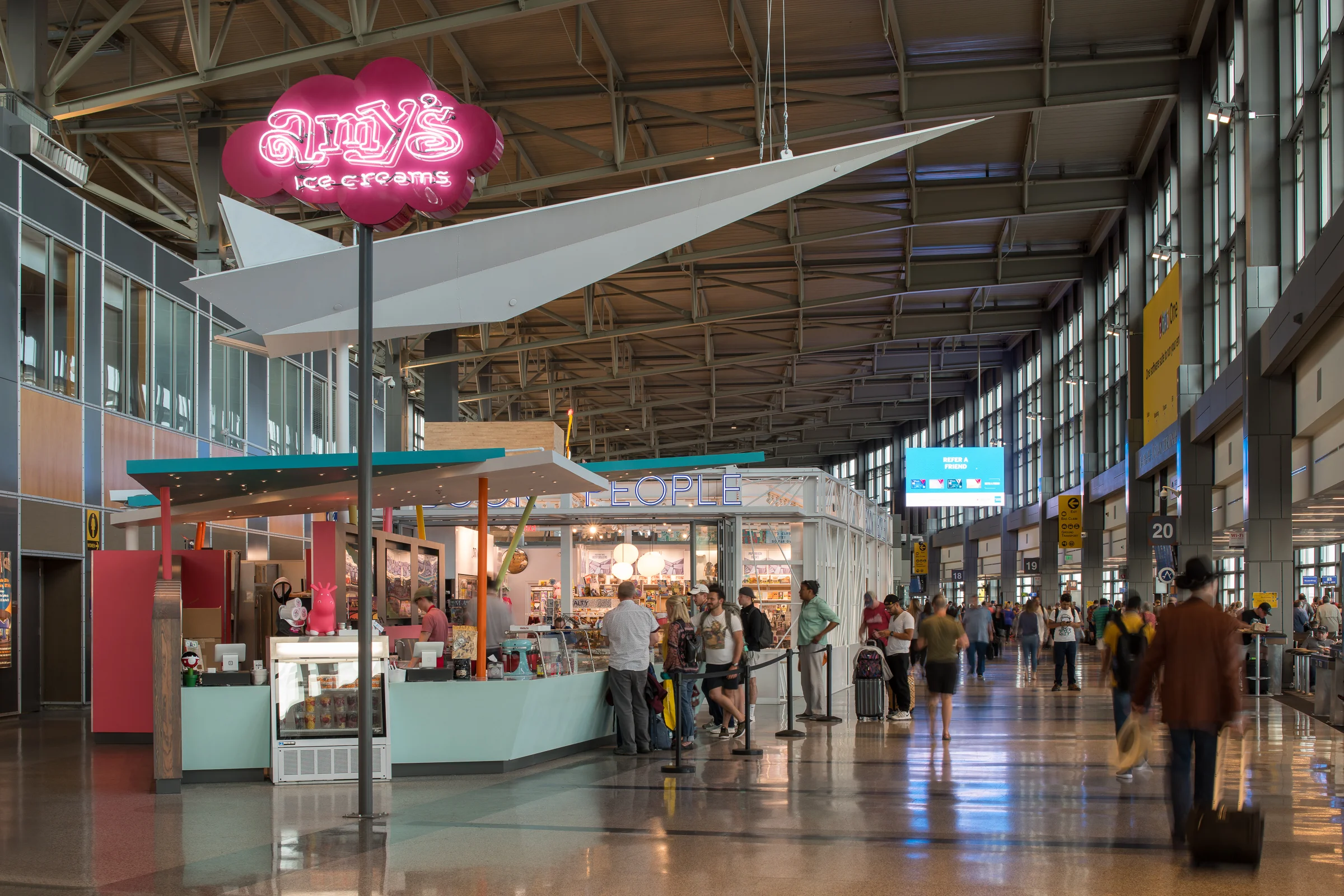AMY’S ICE CREAMS AIRPORT LOCATION Location: Austin-Bergstrom International Airport Size: 690 sf Amy's Ice Creams at the Austin-Bergstrom International Airport is a whimsical service and kitchen kiosk. We drew inspiration from the culture and attitude of Amy's Ice Creams and created a colorful and playful store which serves ice cream across from gate 21. The paper airplane motif was important to Amy's and it is used in dramatic affect as a 30' long canopy and beacon over the kiosk. The store has become a landmark within the airport and is one of Amy's most successful locations. Lemmo Architecture and Design was the Design Architect for this project with Dick Clark + Associates acting as the Architect of Record. Contractor : Trinity Constructors Photo Credits : Paul Bardagjy