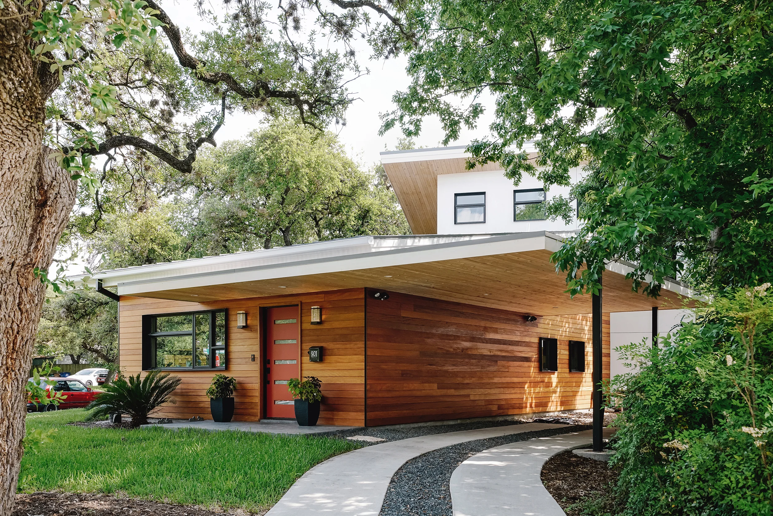 ANNIE BOULDIN This residence in the Bouldin Creek neighborhood of Austin was designed for two individuals who wanted to cohabit in the home while maintaining independent spaces. Thus, the form and material choices were a result of this. There are two separate driveways-his and hers- and an exterior form of two intersecting volumes clad in two different materials: stucco and garapa wood. The volume shifts to accommodate trees and scales down in elevation to human scale near the sidewalk facing Annie street, adapting to the natural and built contexts of the neighborhood. Deep overhangs and soffits help provide shade. A screened in porch acts as formal element to connect indoor and outdoor spaces and to stitch together the volumes. The result is one whole made up of two distinguishable, but not fully distinct, pieces. Contractor : JGB Custom Homes Structural Engineer : Fort Structures Photo Credits : Chase Daniel