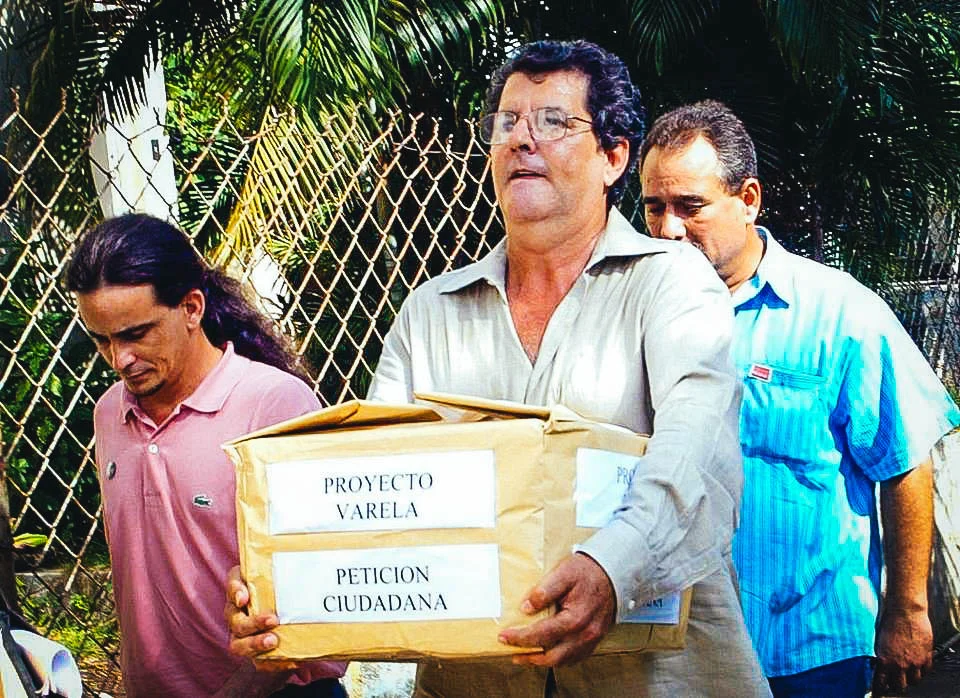 Oswaldo Payá (centro), líder del Movimiento Cristiano Liberación, lleva una caja con las 14,000 firmas en apoyo del Proyecto Varela, en octubre del 2003, en La Habana. JOSE GOITIA AP Read more here: http://www.elnuevoherald.com/opinion-es/opin-col-blogs/opinion-sobre-cuba/article120058828.html#storylink=cpy