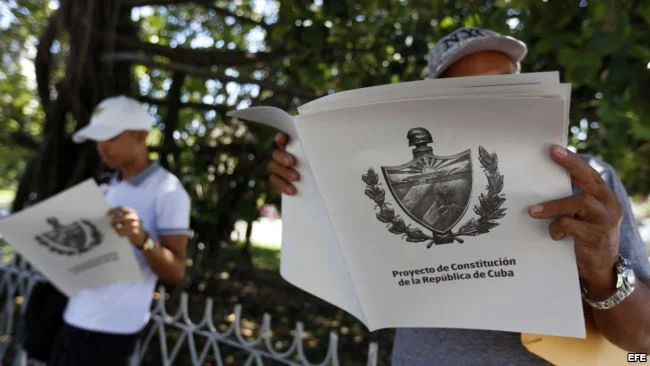 Dos personas leen el Proyecto de Constitución de la República de Cuba