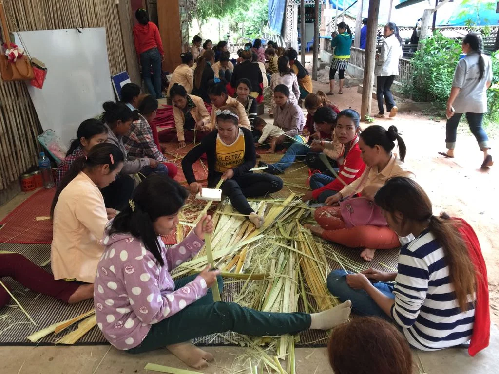 Girls learning weaving skills.