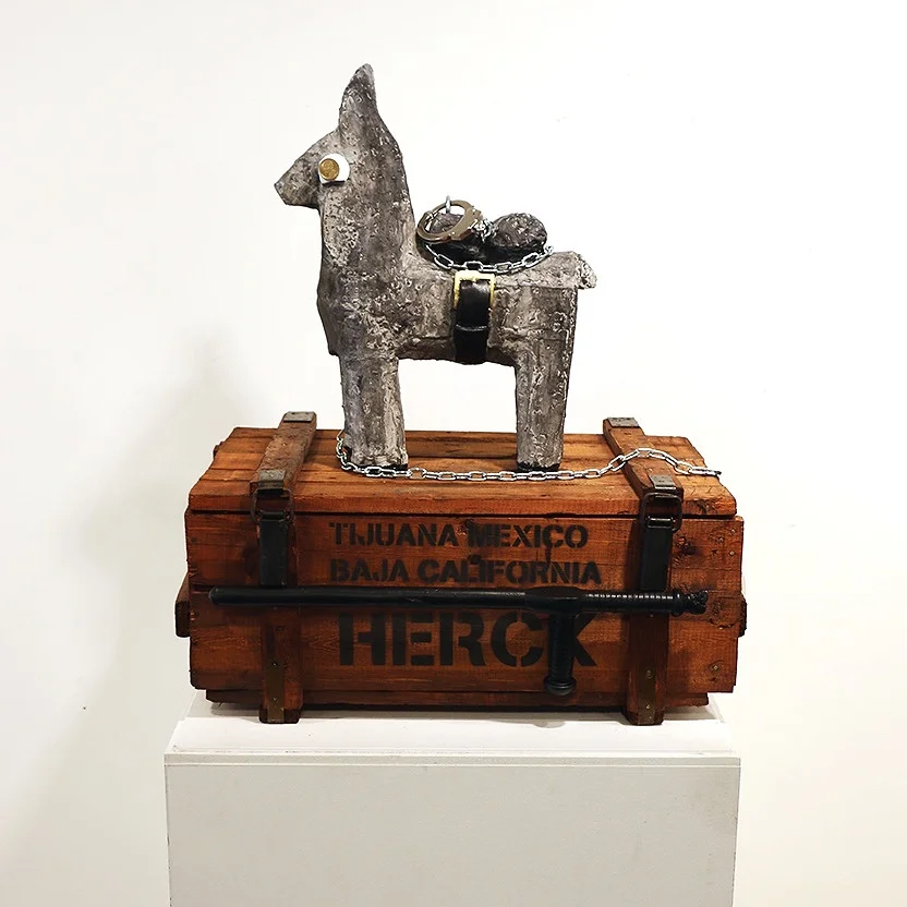 The War On Drugs 2019 19 kg Concrete piñata 53 x 37 x 15 cm Steel chain 200 cm Steel handcuffs regular size Pile wooden box 32 x 75 x 48 cm Full black polyster baton 60 x 15 x 3 ∅ cm © Tom Herck