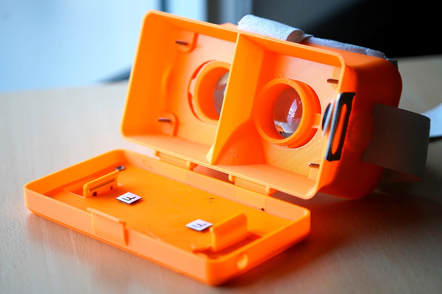 Abierto. Se ven las lentes con dioptría ajustable y el sostén del smartphone.