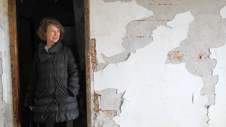 Sunny Fischer, board chairwoman of the National Public Housing Museum, stands beneath a rusty door frame in the former public housing building in the 1300 block of West Taylor Street that will house the museum. (Abel Uribe / Chicago Tribune)