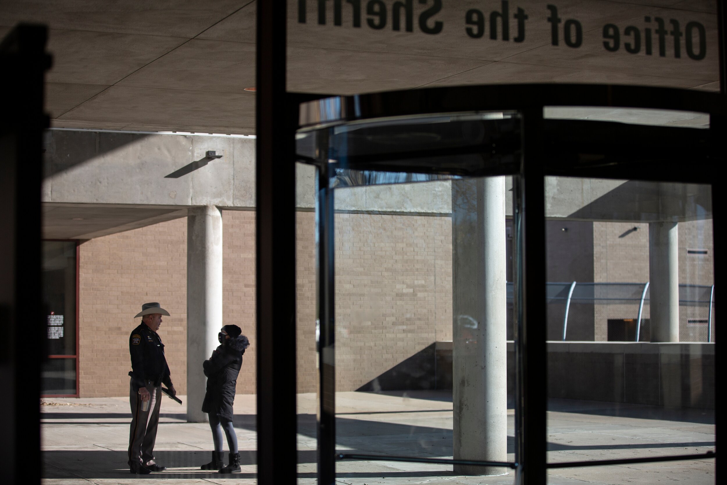  Elizabeth Michel follows an officer outside out of frustration after a press conference. 