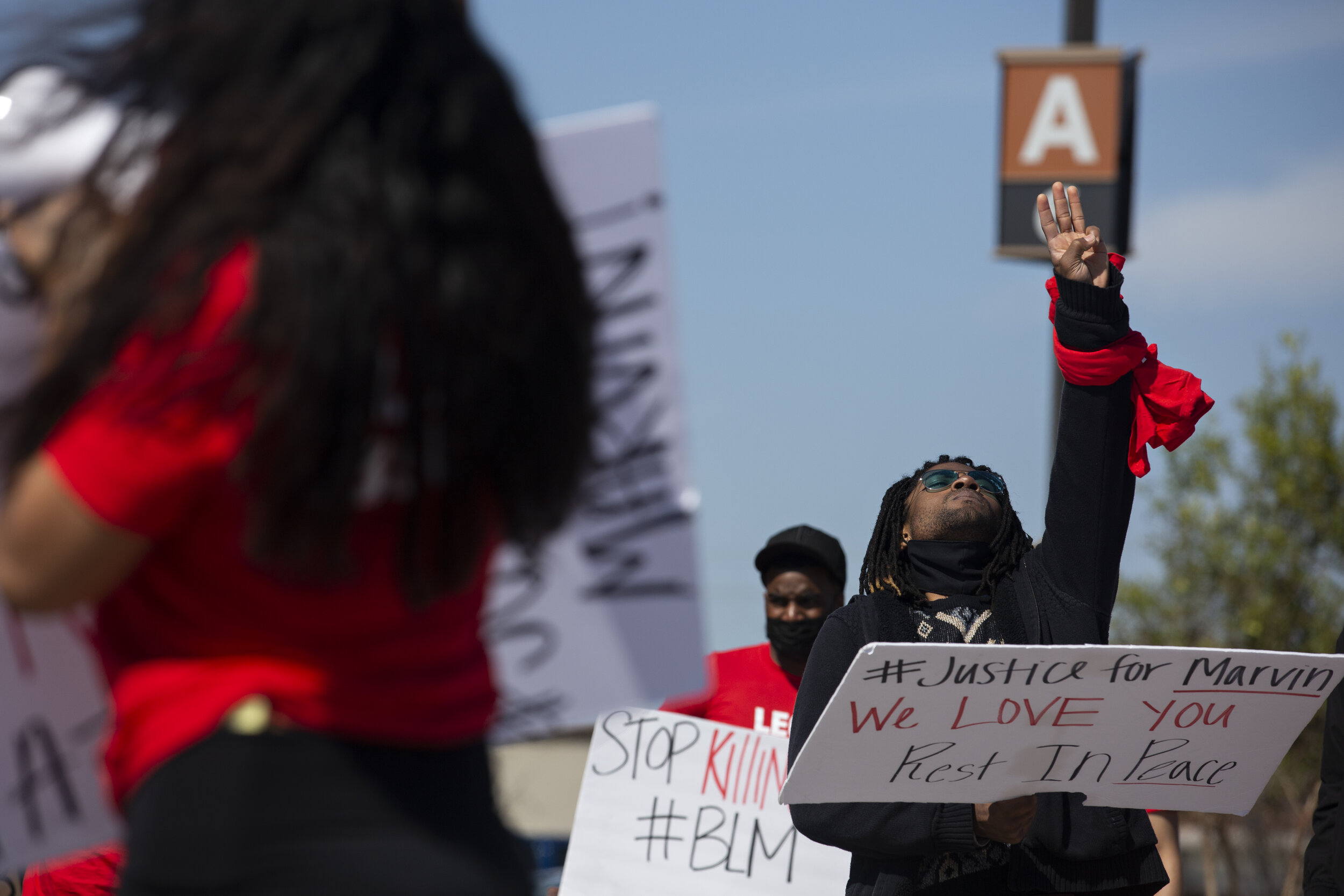  Quinten Scott holds up three fingers for his older brother Marvin Scott III during a march through the Allen Outlets. “I’m just now to a point where I feel I can speak”, said Quinten after leading several chants and telling the crowd stories of his 