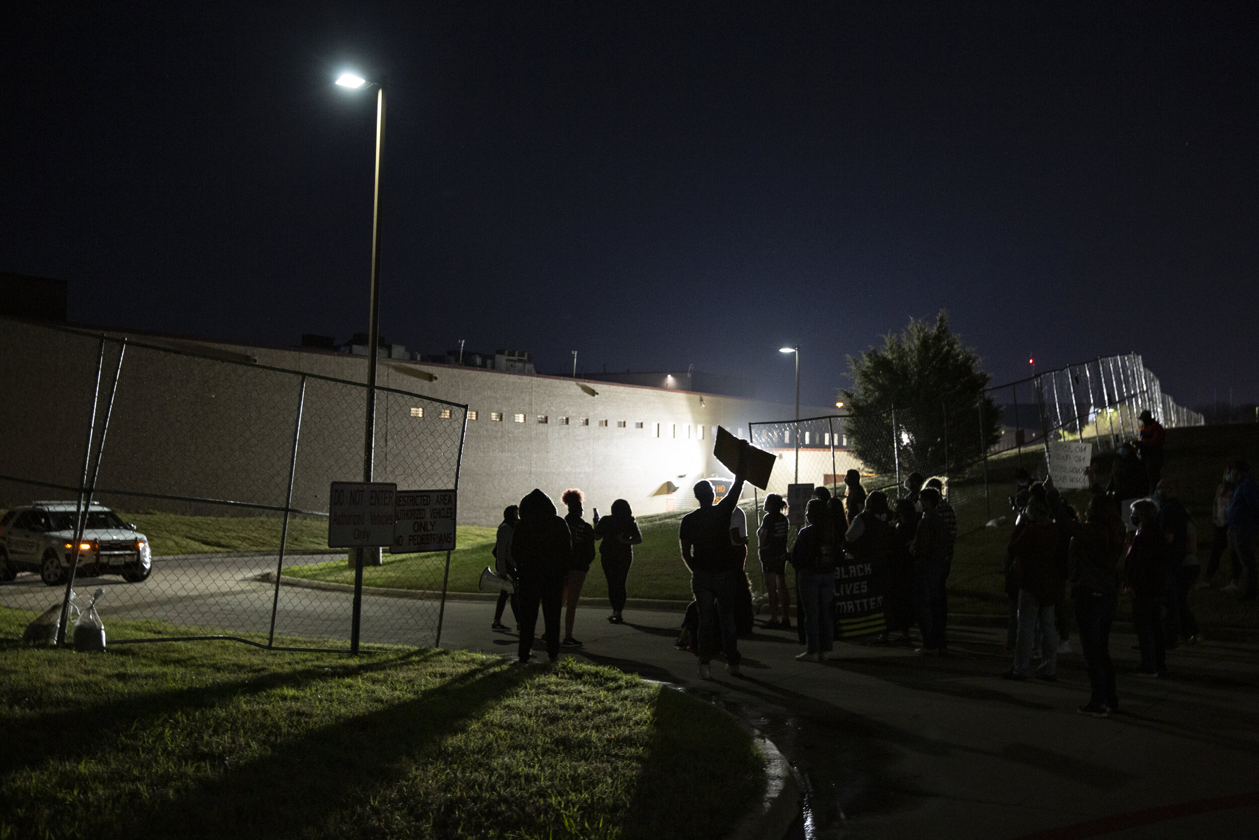  A fence was put up to block demonstrators from their original protest location, the inmate driveway, on March 26, 2021. The group still marched along the perimeter.   