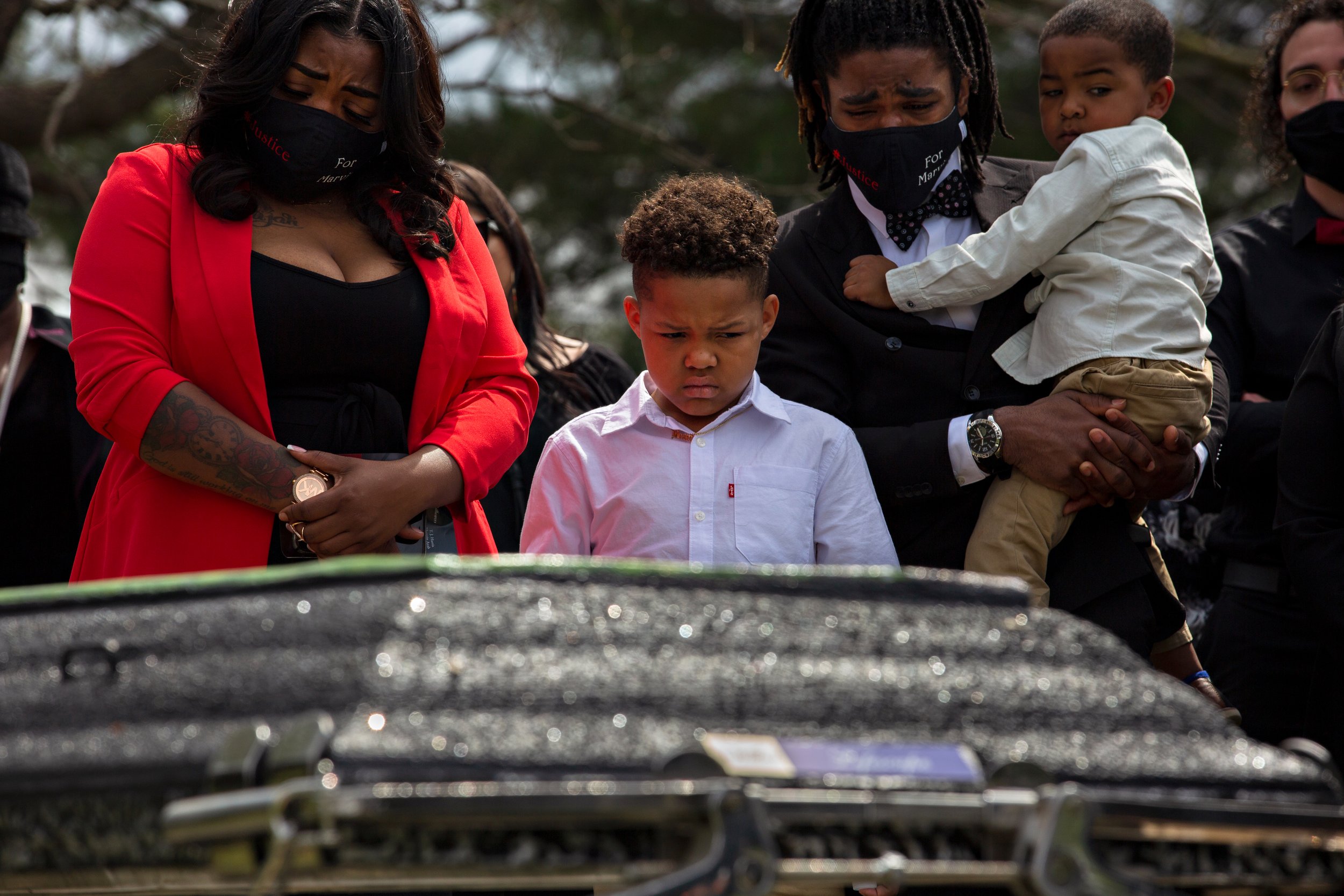  LaChay Batts, her son Elijah Lyons, her brother Quinten Scott and her youngest son Rylan surround the casket of Marvin Scott III at his funeral. 