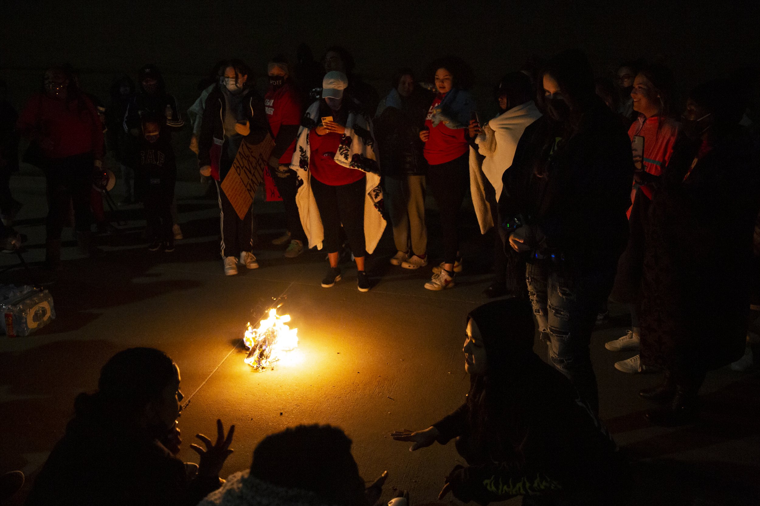  Demonstrators gather around a fire, set to block the driveway used to bring inmates in for booking at the Collin County Jail, as they meet each other and share stories. Attorney Lee Merritt encouraged those who gathered to get to know each other. “I