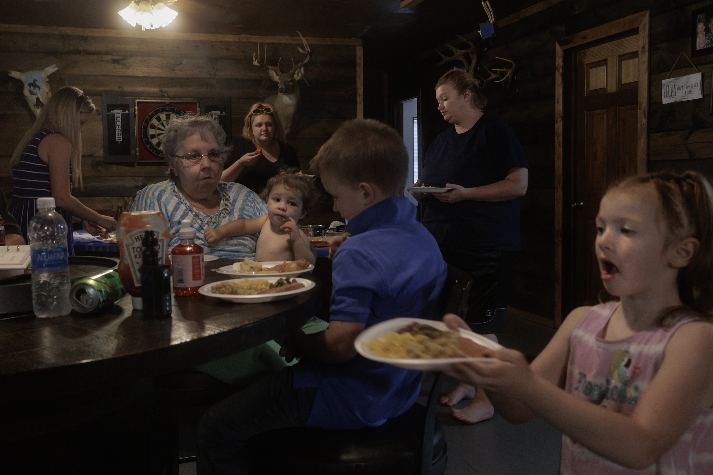  Michel’s family serves themselves plates of ham, mac and cheese, mashed potatoes and green beans. With Miranda on bedrest and Levi taking on extra shifts at the Tyson chicken processing plant to keep up with bills, Miranda’s sister moved in to help 