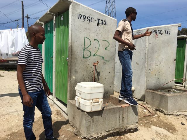 Community Activists with the Social Justice Commission explain toilet options for residents of the Khayelitsha township in Cape Town, South Africa.