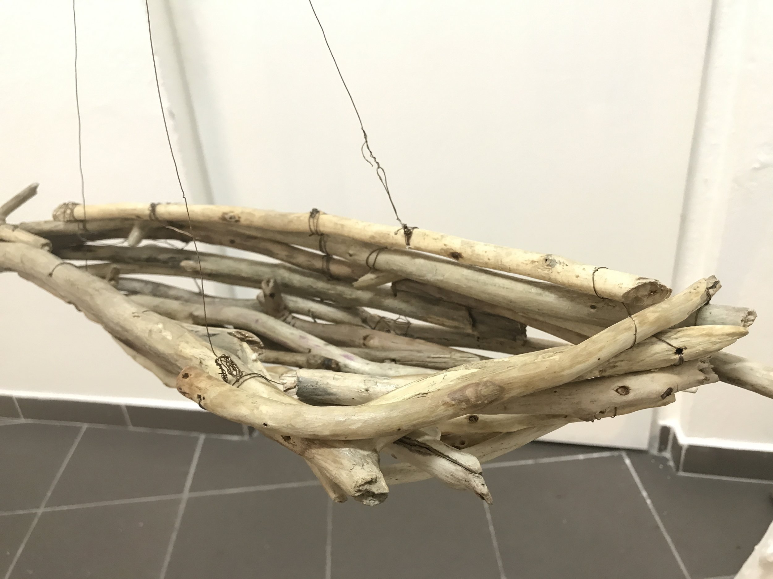  One of four boats made of driftwood and copper wire, each piece of wood burnished by hand. Three boats are suspended above the ‘river’ by thin wires strung from large natural wood tripods. Installation is easily reconfigured to fit any space.  
