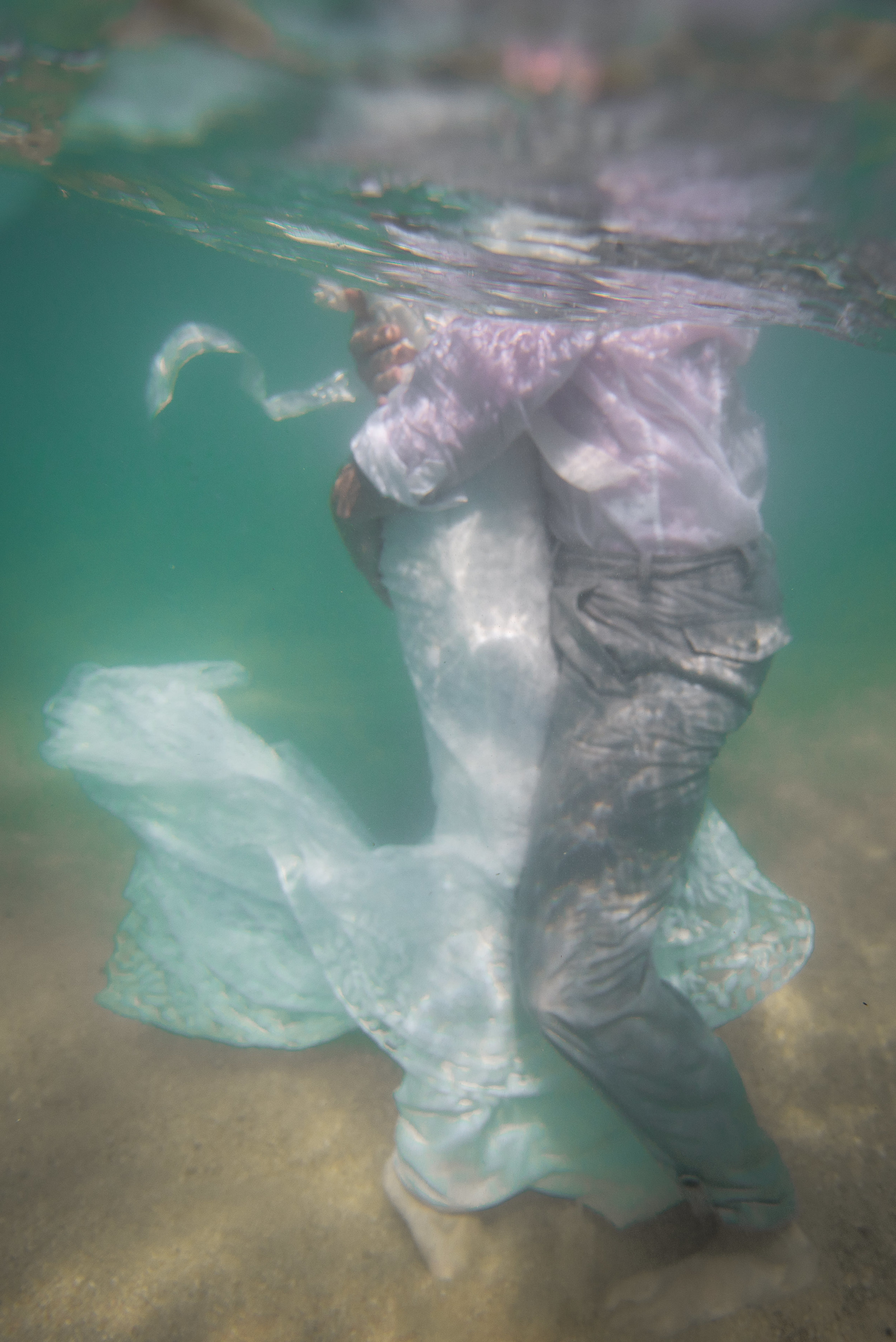 Underwater picture with bride and groom holding each other during their Trash The Dress session in Los Cabos