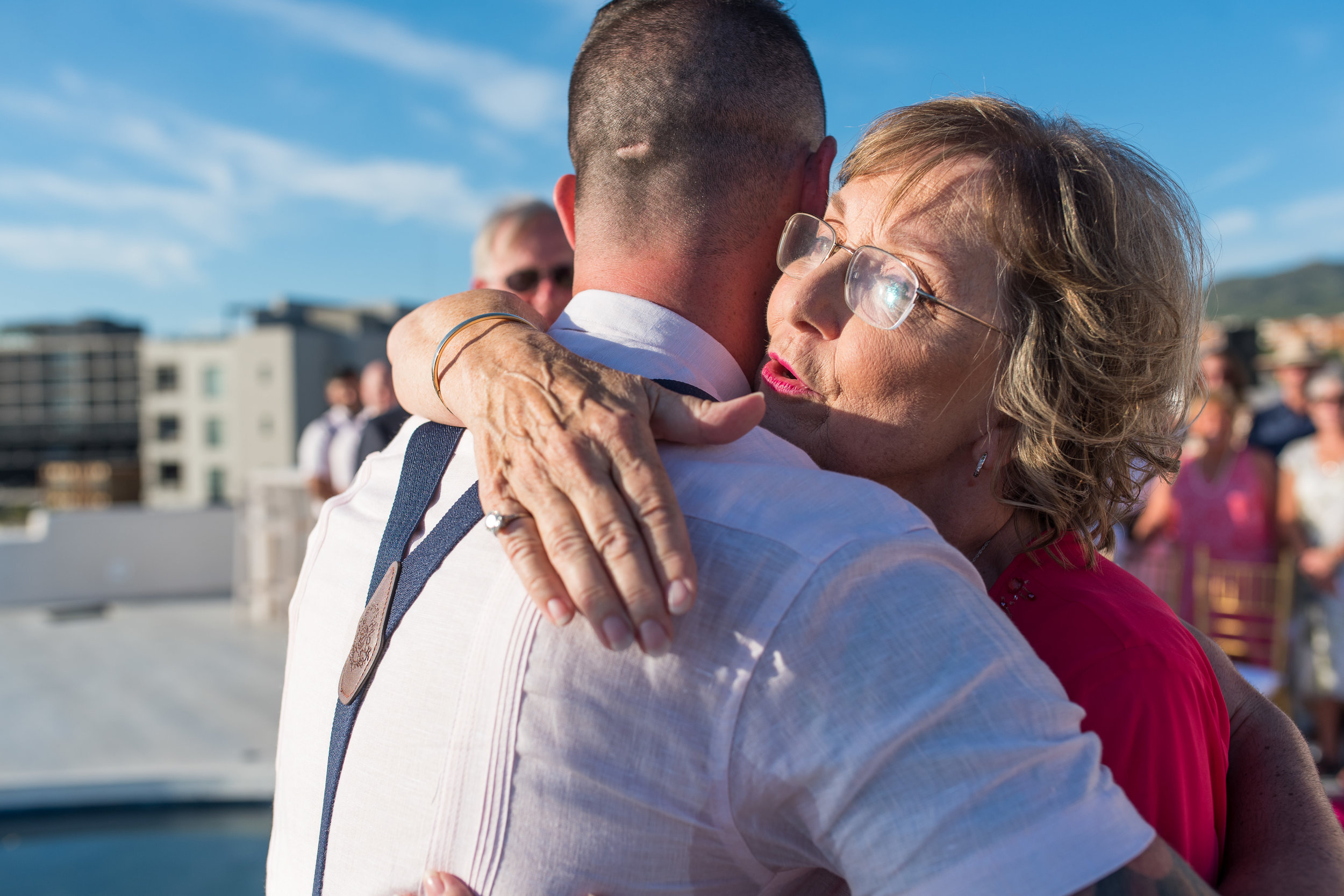 Mother of the bride hugs groom at altar